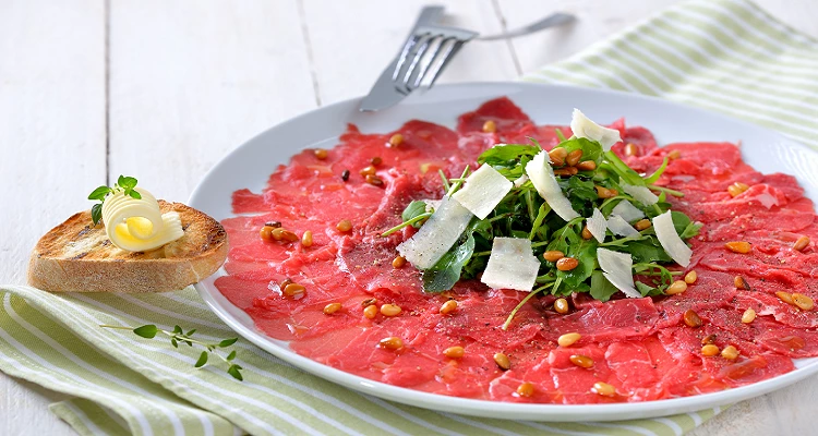 Carpaccio vom Strauß mit Parmesan, Rucola und Pinienkernen